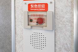 緊急按鈕為紅色按鈕，設置於每節車廂內通道門旁